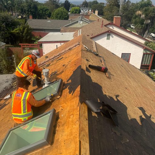 Workers installing skylights on roof.